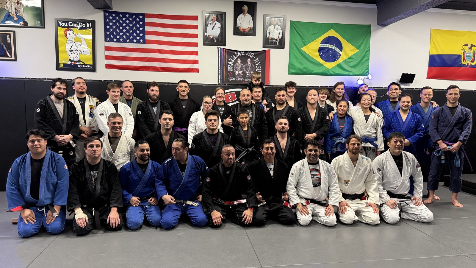 The full Soca BJJ Glen Cove team lined up on the mats beneath the American, Brazilian, and Ecuadorian flags